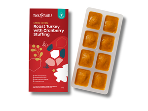 Tiny Turtle baby food packaging with red label and white tray with orange squares on a white background