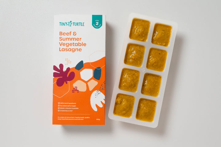 Beef and summer vegetable lasagne Stage 2 baby food by Tiny Turtle, featuring textured puree in tray next to packaging.
