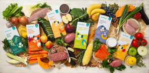 Assorted fresh produce and food packages arranged on a wooden surface