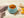 Blue bowl with orange spread on a wooden surface with a napkin and oranges.