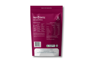The back of a magenta stand-up pouch for Tiny Turtle Soft Llama Kaffos, showing nutritional information, a barcode, and a white panel at the bottom, photographed on a white background.