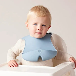 Bbox silicone bib on a baby in a high chair, designed to catch food, made of non-toxic silicone, easy to clean.
