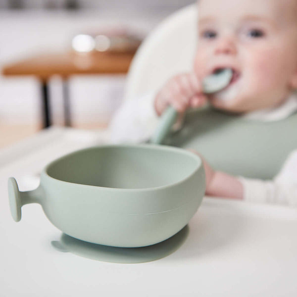 Bbox silicone suction bowl in soft green, designed for toddlers, featuring a strong base and easy grip handle for independent eating.