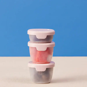 Three colorful b.box Snack Tubs stacked on a table, featuring secure hinged lids for yoghurts and dips.