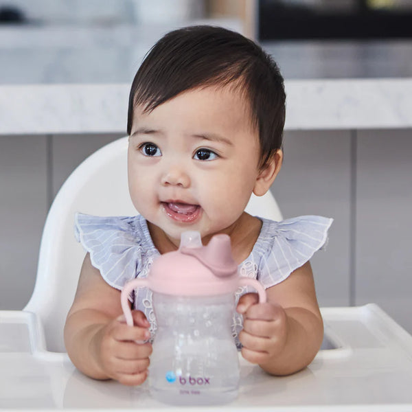 Happy baby holding the Bbox spout cup, ready for easy and comfortable drinking.