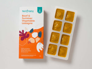 Beef and summer vegetable lasagne Stage 2 baby food by Tiny Turtle, featuring textured puree in tray next to packaging.