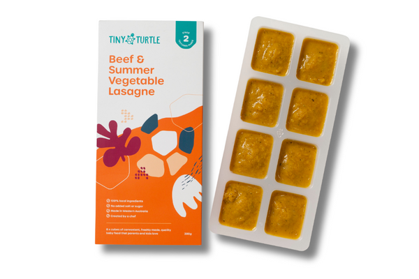Beef and summer vegetable lasagne Stage 2 baby food by Tiny Turtle, featuring textured puree in tray next to packaging.