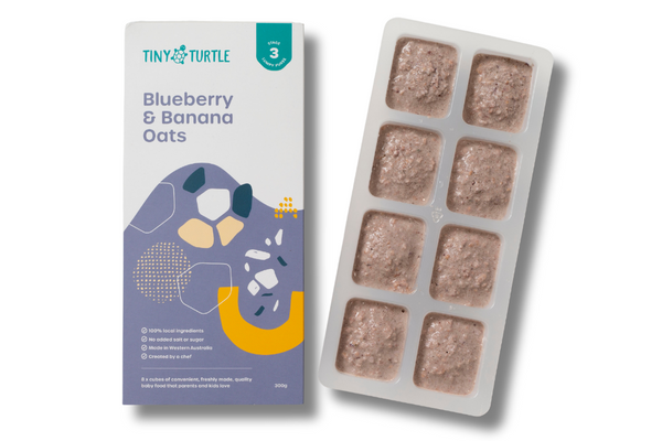 Packaging of Tiny Turtle baby food with a tray of food cubes on a white background