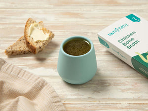 Tiny turtle chicken bone broth in a cup with some bread