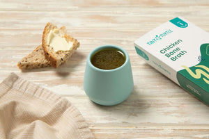Tiny turtle chicken bone broth in a cup with some bread