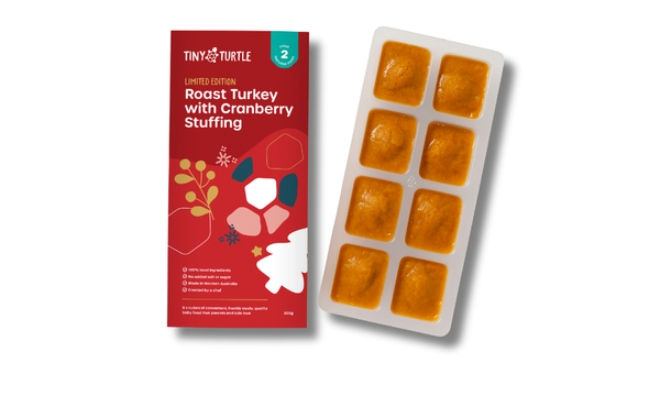 Tiny Turtle baby food packaging with red label and white tray with orange squares on a white background