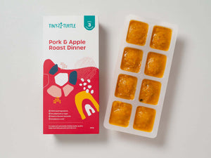Pork and Apple Roast Dinner Stage 3 baby food by Tiny Turtle, featuring lumpy textured puree in tray next to packaging.