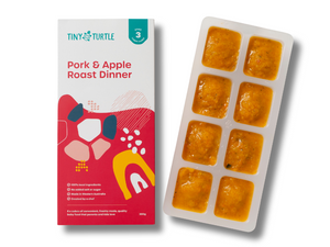 Pork and Apple Roast Dinner Stage 3 baby food by Tiny Turtle, featuring lumpy textured puree in tray next to packaging.