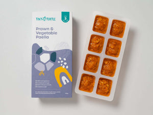 Stage 3 Prawn & Vegetable Paella baby food by Tiny Turtle, featuring 8 frozen puree cubes in tray next to product packaging.