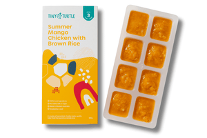 Tiny Turtle baby food packaging with a tray of yellow baby food cubes on a white background