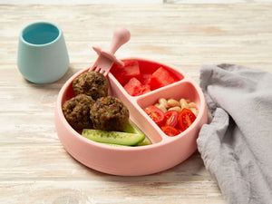 Baby beef meatballs on a pink plate with cucumber and tomato 