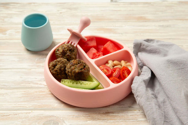 Baby beef meatballs on a pink plate with cucumber and tomato 